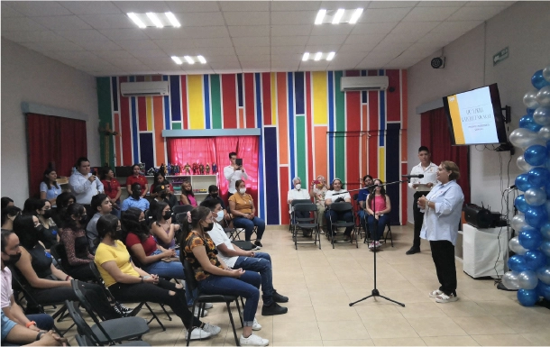 Grupo de padres de familia asistiendo a una plática informativa y de formación en el salón de usos múltiples.